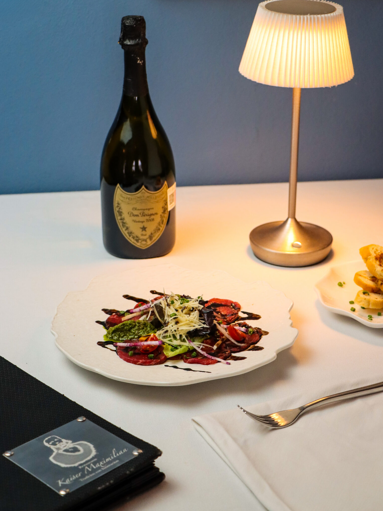 Carpaccio con queso parmesano y vino espumoso en Kaiser Maximilian Puerto Vallarta